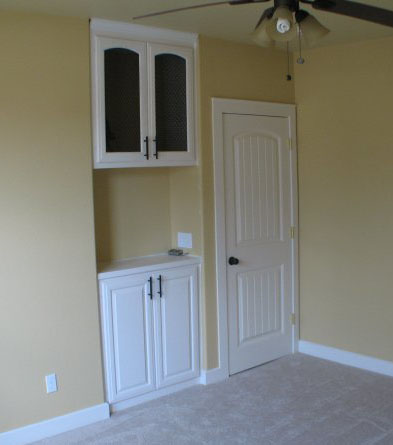 Space behind the walls was used to build 2 cabinets in this bedroom.